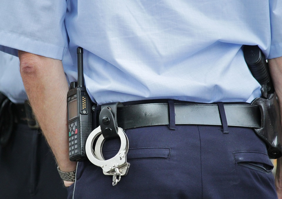 Ein Polizist mit Walkie-Talkie und Handschellen